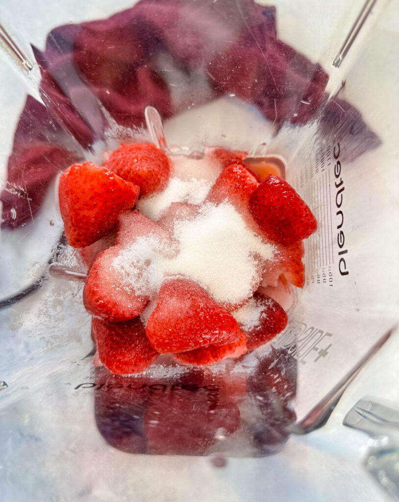 strawberries, sugar, and water in a blender