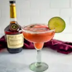 Hennessy margarita in a glass with strawberries and lime