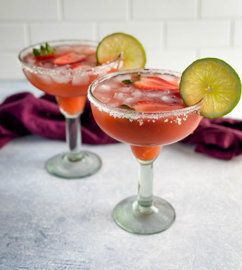 Hennessy margarita in a glass with strawberries and lime