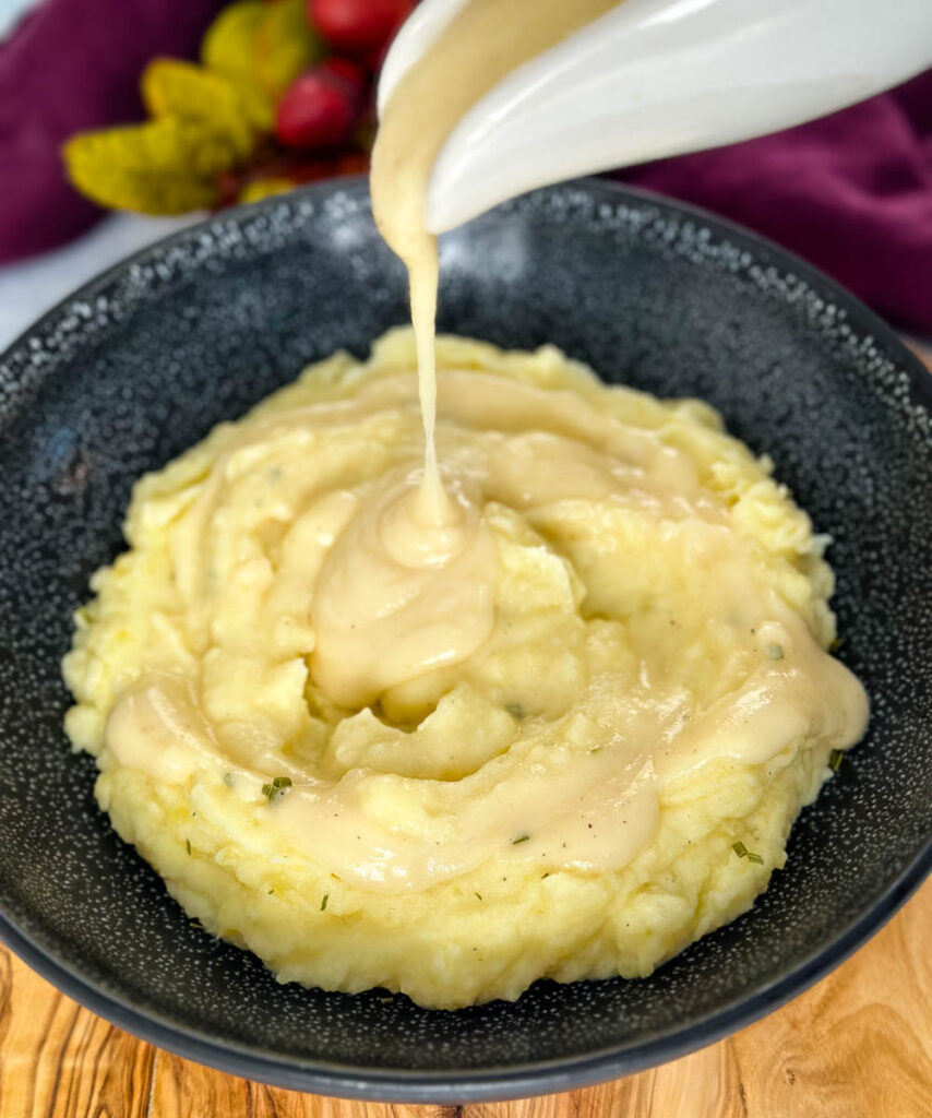 gravy drizzled over buttermilk mashed potatoes in a bowl