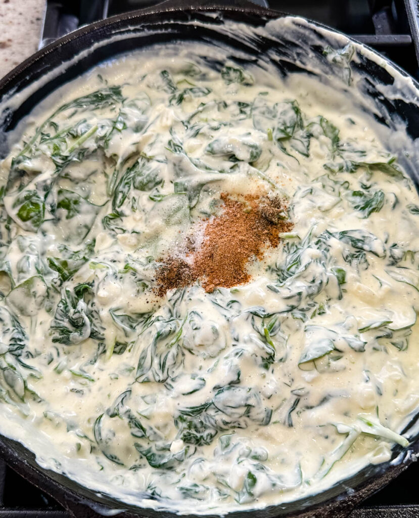 steakhouse creamed spinach in a cast iron skillet with nutmeg and spices