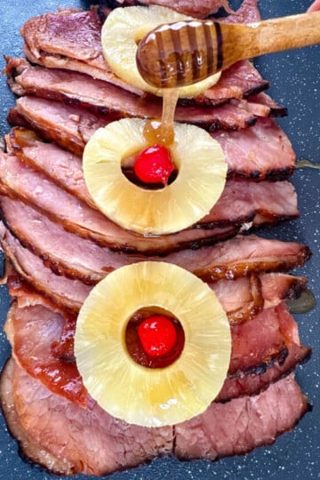 slow cooker crockpot ham on a plate with pineapples and glaze