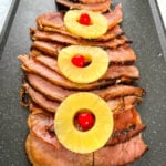 slow cooker crockpot ham on a plate with pineapples and glaze