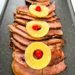 slow cooker crockpot ham on a plate with pineapples and glaze