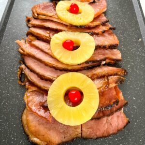 slow cooker crockpot ham on a plate with pineapples and glaze