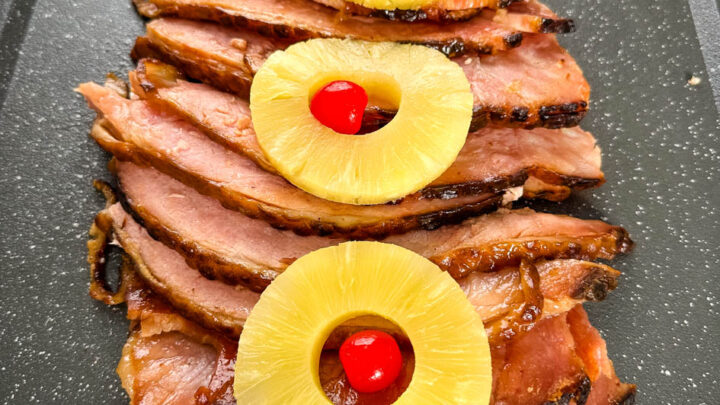 slow cooker crockpot ham on a plate with pineapples and glaze