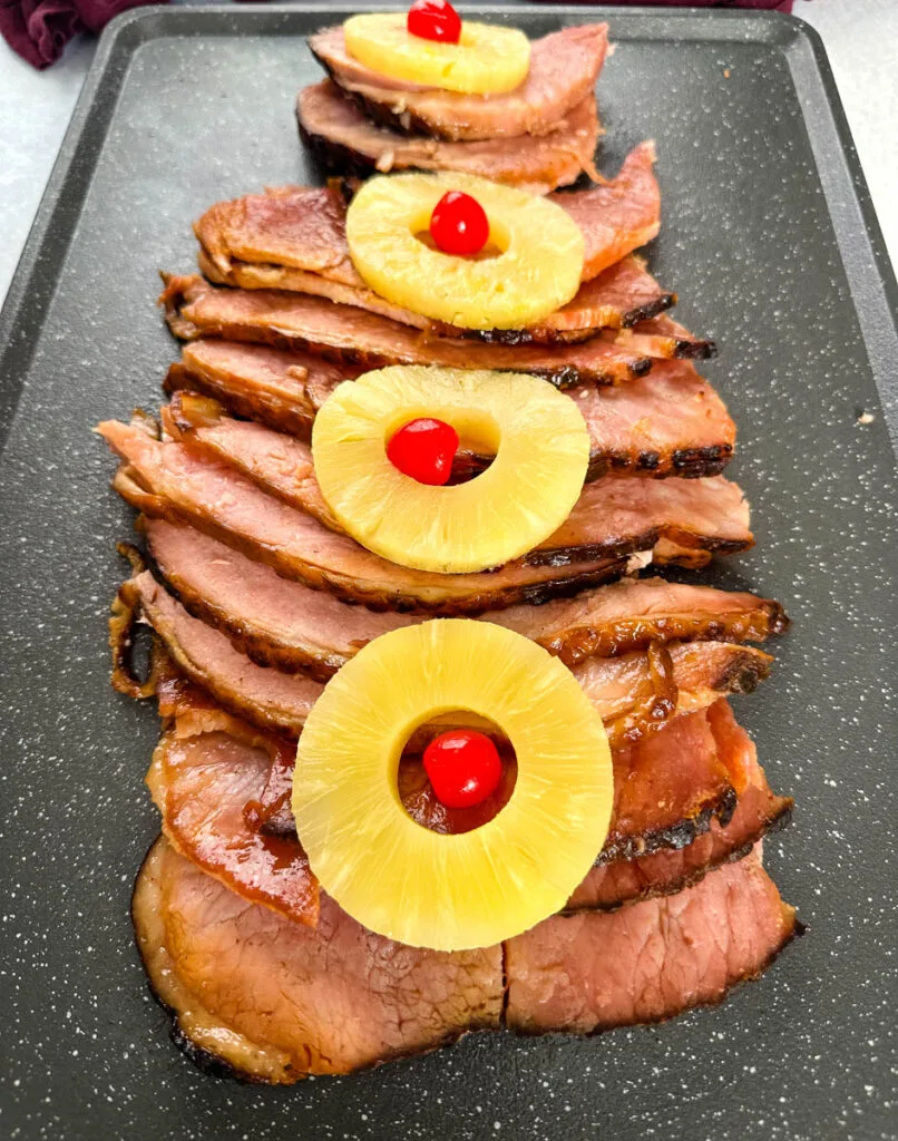 slow cooker crockpot ham on a plate with pineapples and glaze