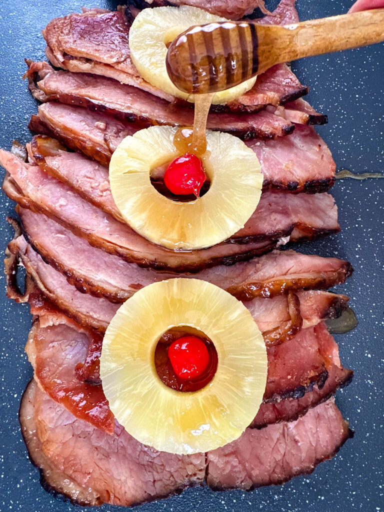 slow cooker crockpot ham on a plate with pineapples and glaze