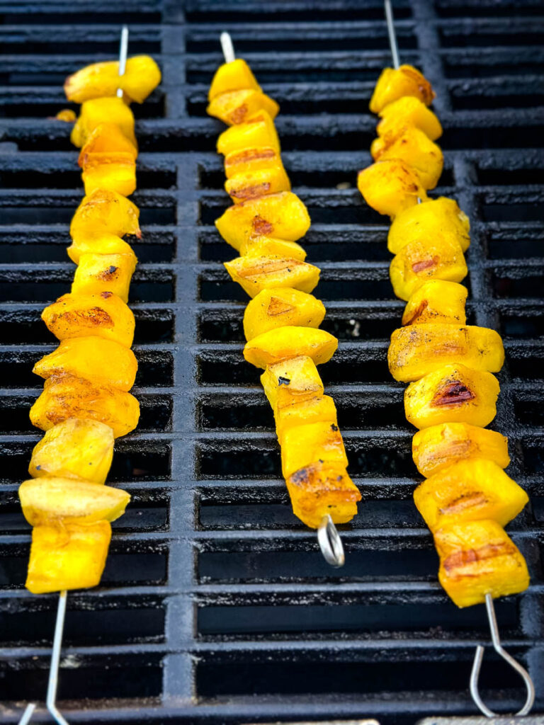 mango on skewers on a grill