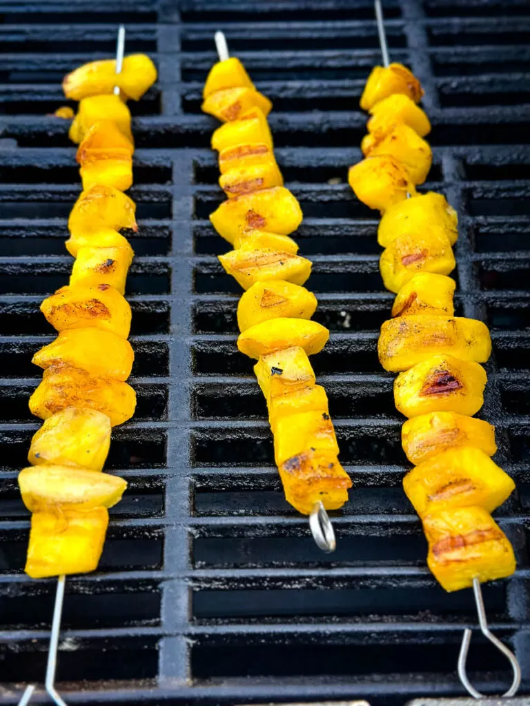 mango on skewers on a grill