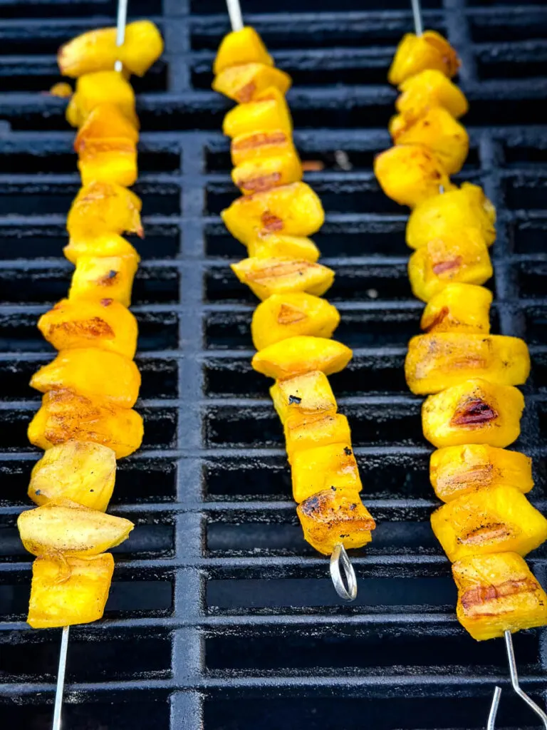 mango on skewers on a grill