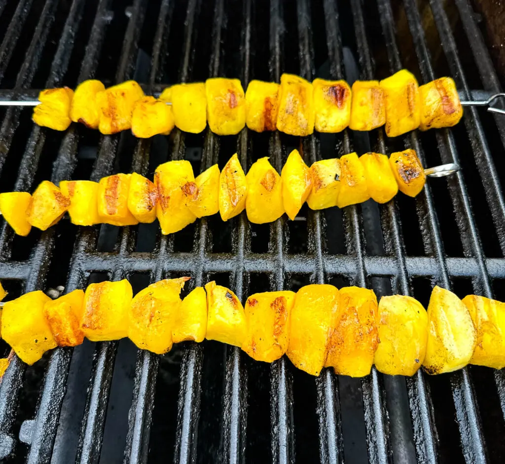 mango on skewers on a grill