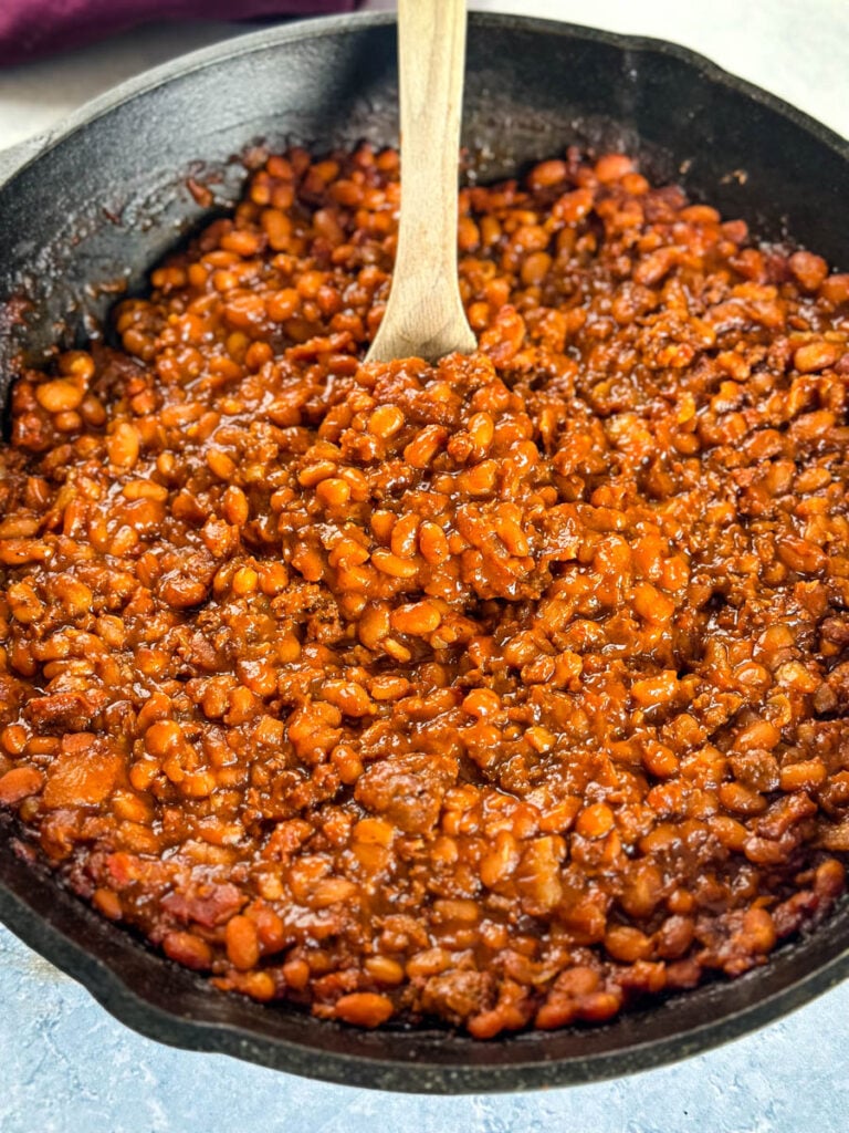 smoked baked beans with ground beef and bacon in a cast iron skillet