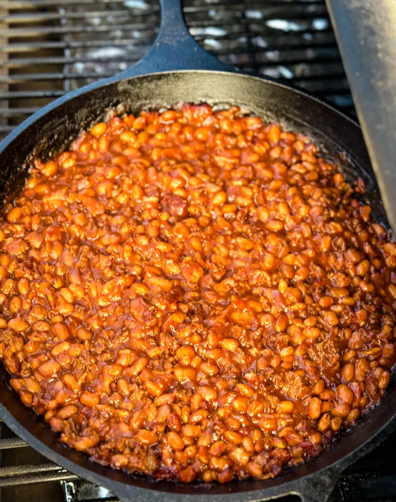 smoked baked beans with ground beef and bacon in a cast iron skillet