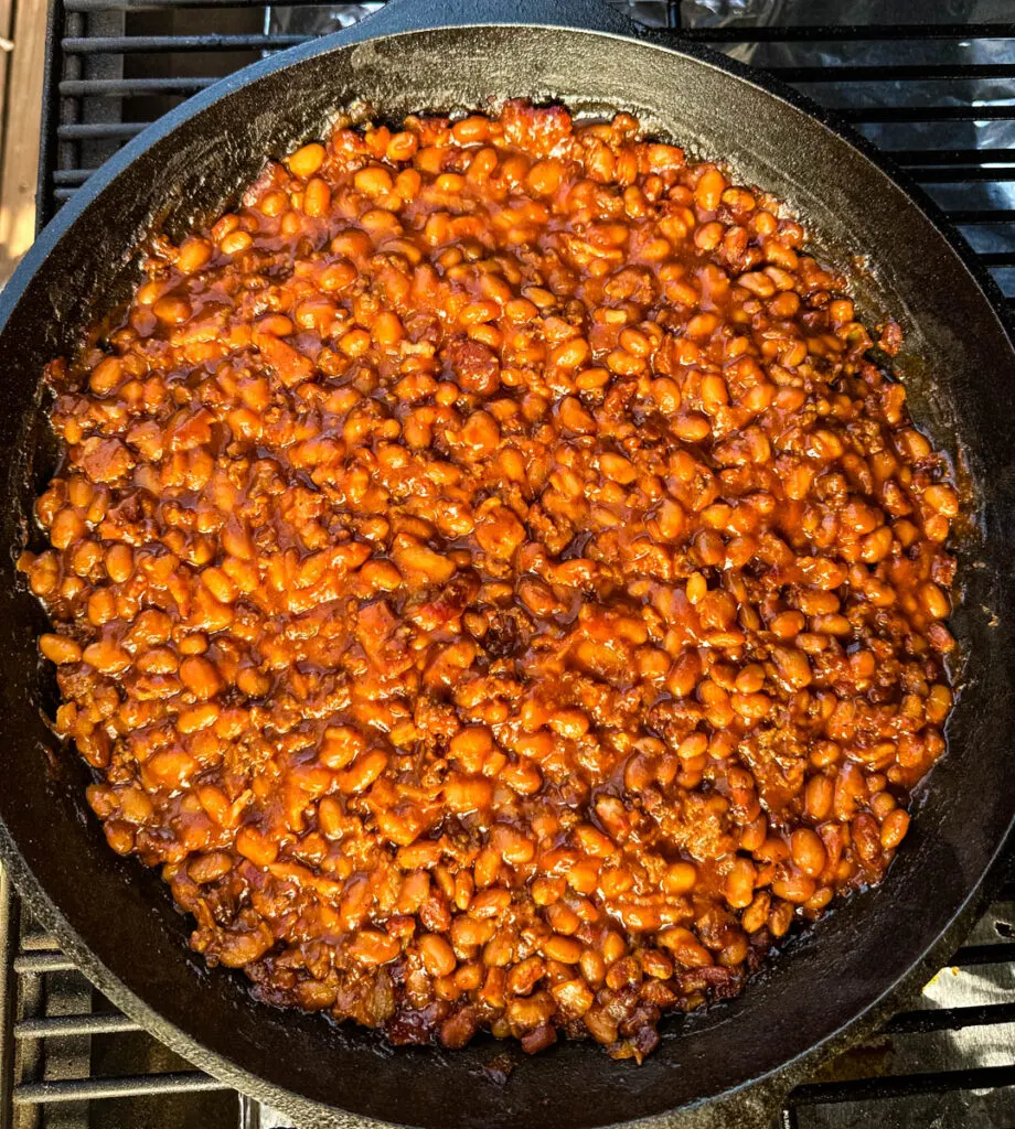 smoked baked beans with ground beef and bacon in a cast iron skillet