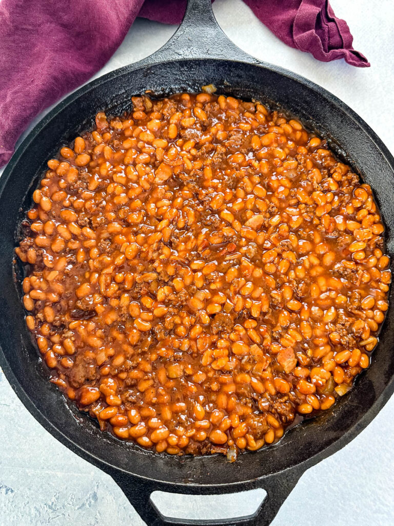 smoked baked beans with ground beef and bacon in a cast iron skillet