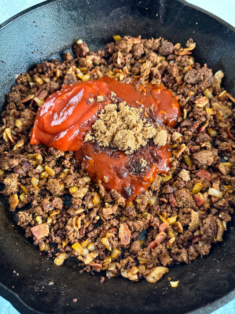 baked beans with ketchup, brown sugar in a cast iron skillet