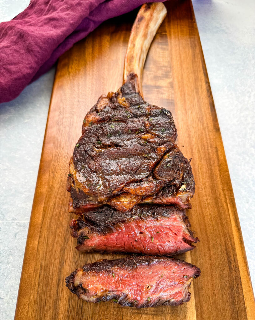 sliced medium or medium rare tomahawk steak on a platter