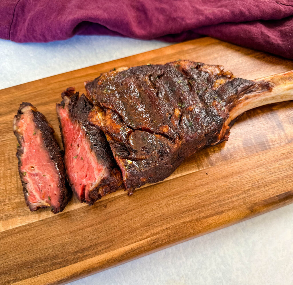 sliced medium or medium rare tomahawk steak on a platter