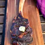 smoked tomahawk steak with butter on a platter