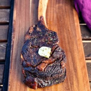 smoked tomahawk steak with butter on a platter