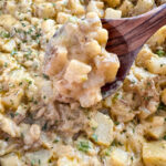 smothered potatoes with onions, peppers, and gravy in a cast iron skillet