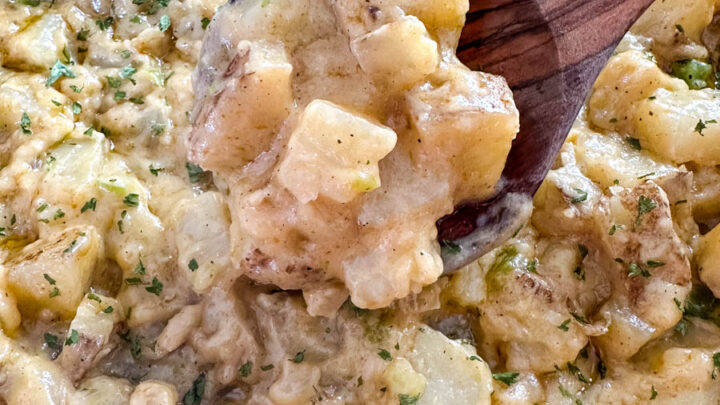 smothered potatoes with onions, peppers, and gravy in a cast iron skillet