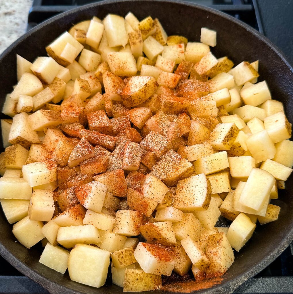 fried potatoes, onions, and peppers in a cast iron skillet