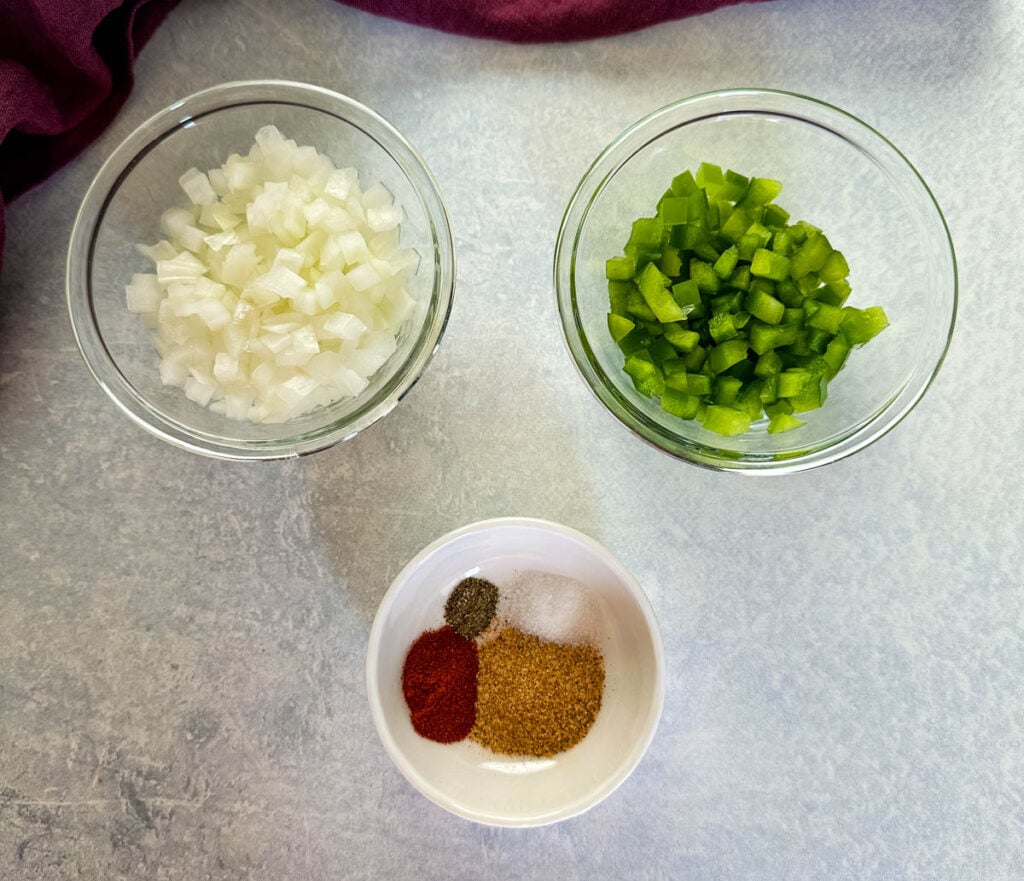 chopped onions, chopped green peppers, and spices in separate bowls