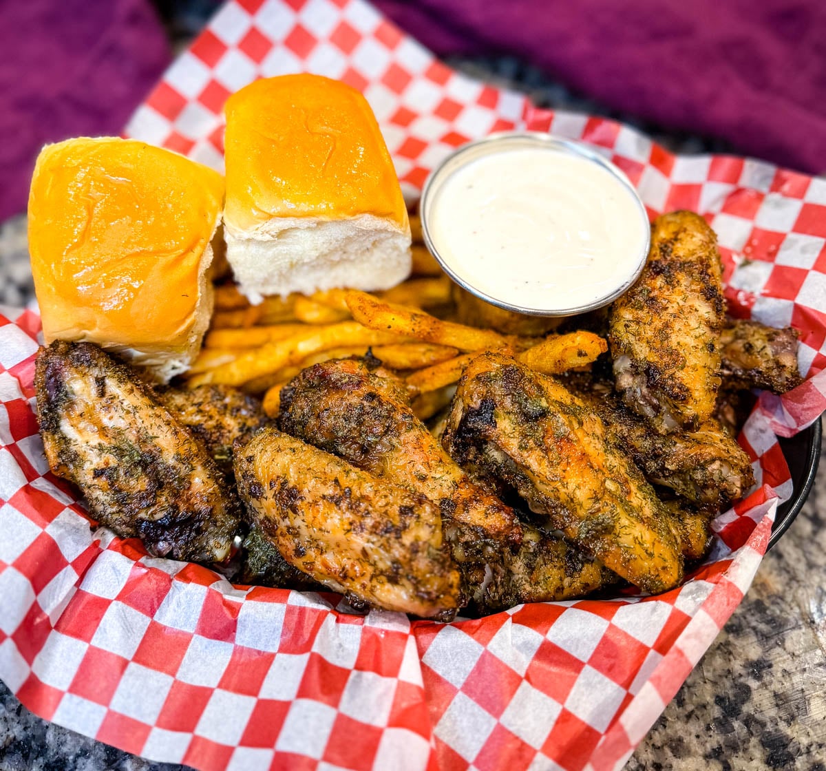 ranch seasoned wings, fries, and a bread roll in a bowl