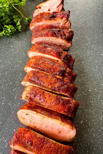 sliced smoked pork tenderloin on a flat surface