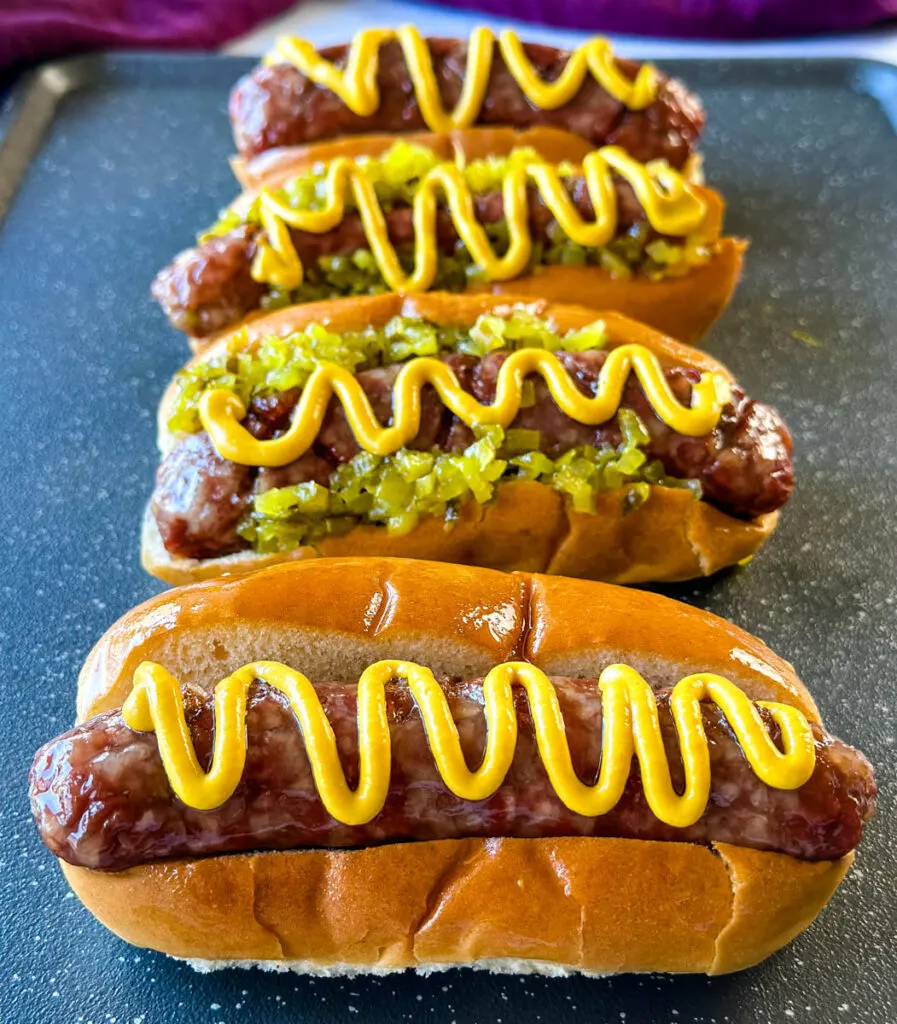 smoked brats on buns with mustard and relish