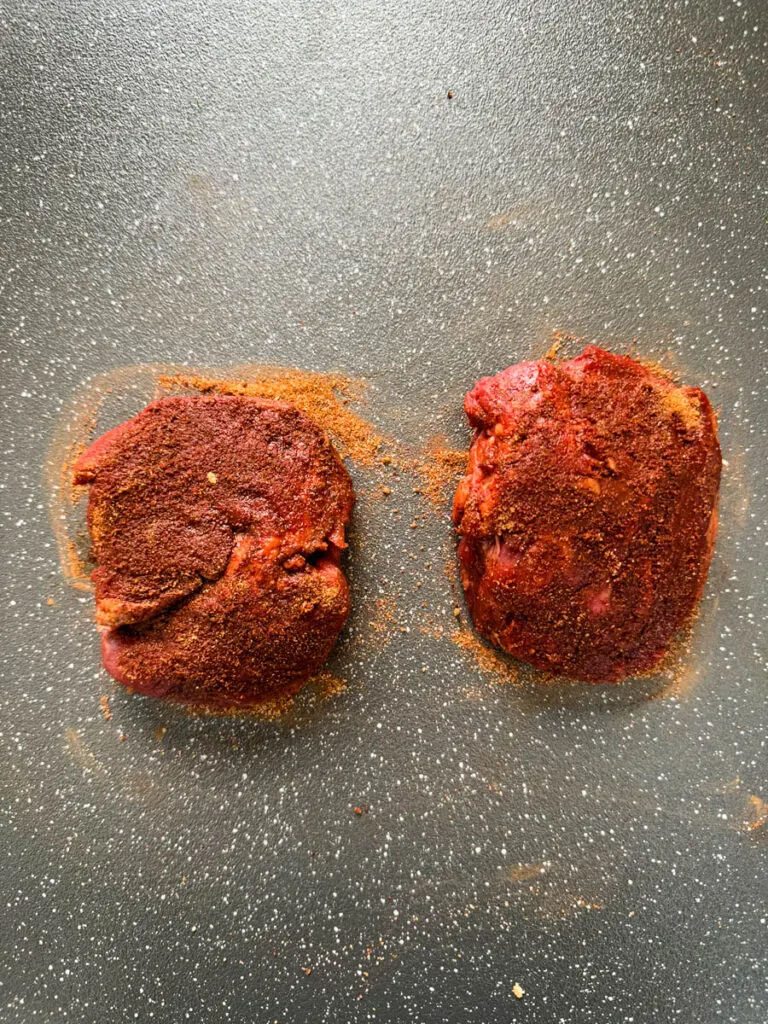 raw seasoned filet mignon on a plate