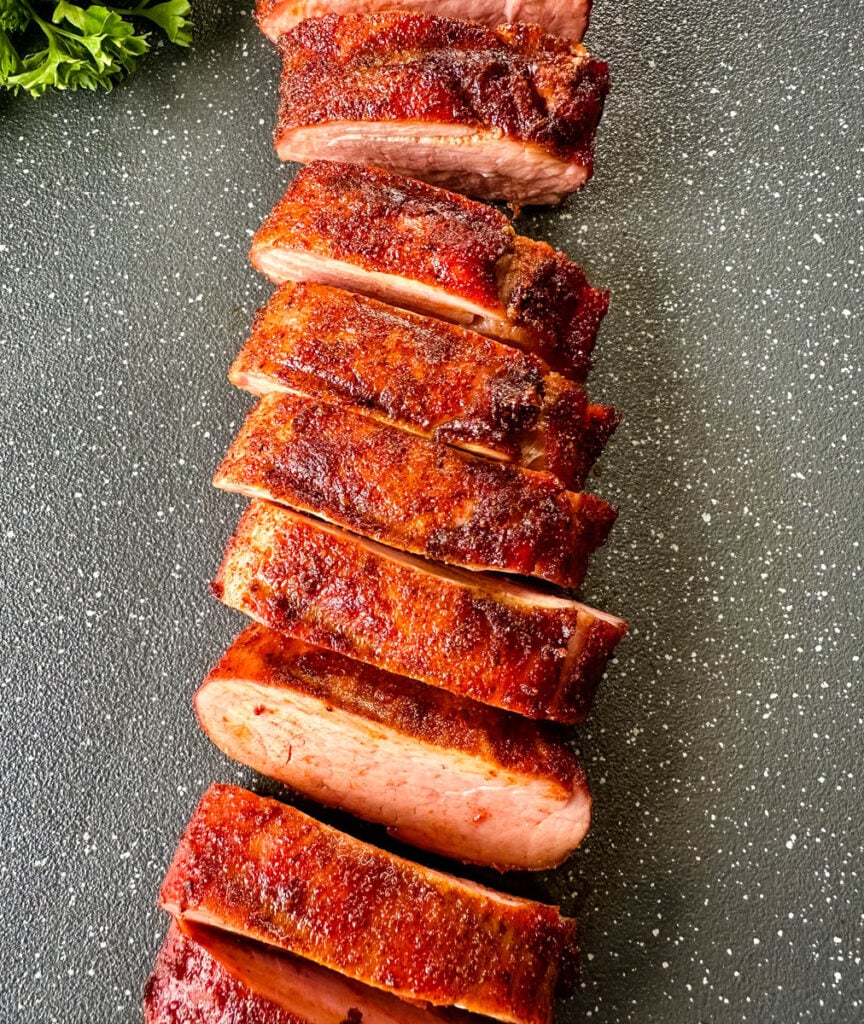 sliced smoked pork tenderloin on a flat surface