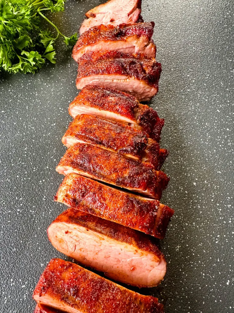 sliced smoked pork tenderloin on a flat surface