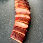 sliced smoked pork tenderloin on a flat surface