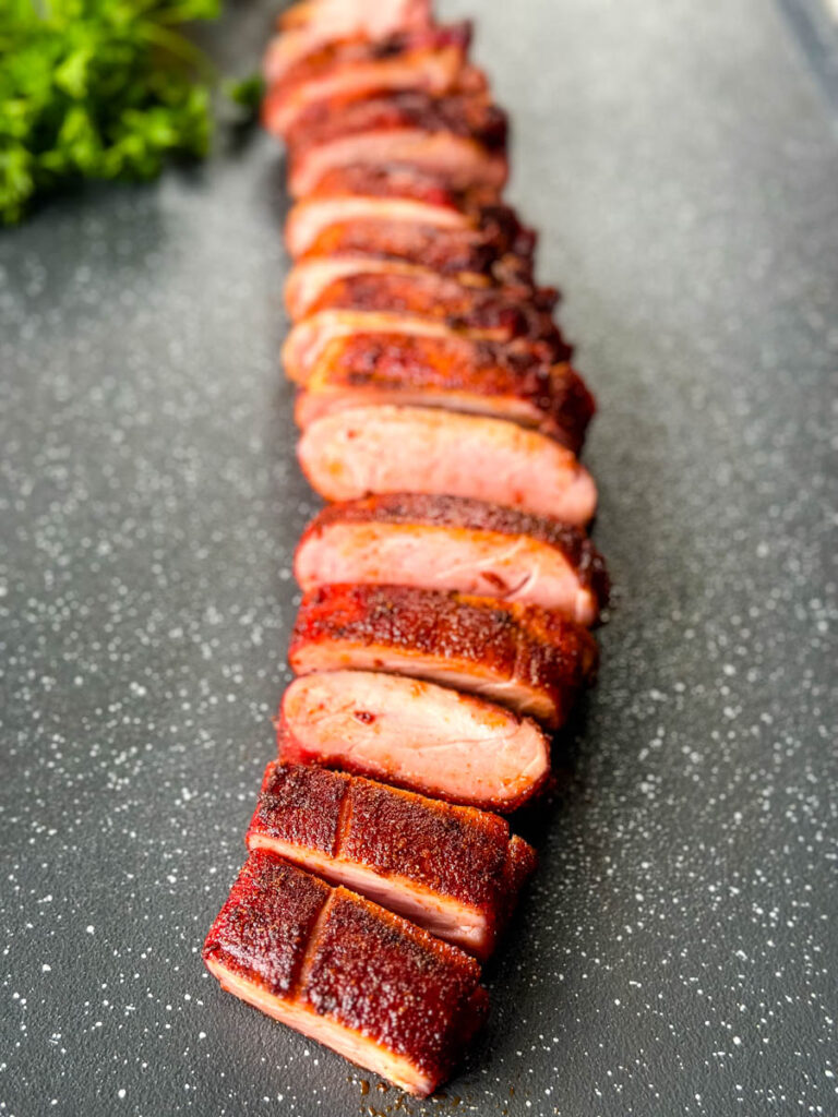 sliced smoked pork tenderloin on a flat surface