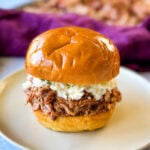 smoked pulled pork sandwich which coleslaw on a plate