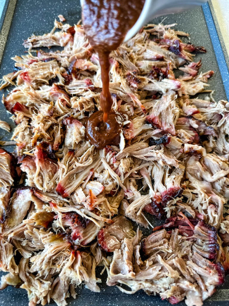 smoked pulled pork drizzled in BBQ sauce on a plate