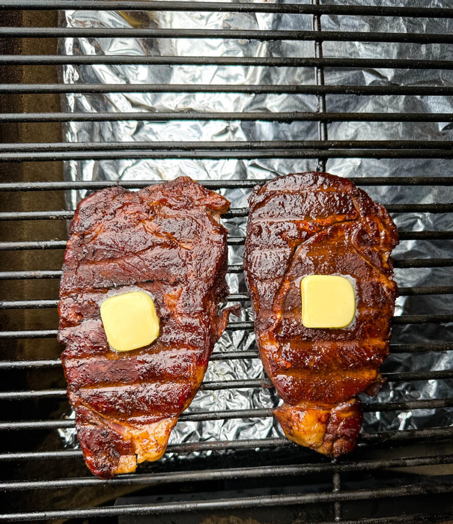 smoked ribeyes with butter on a Traeger smoker grill