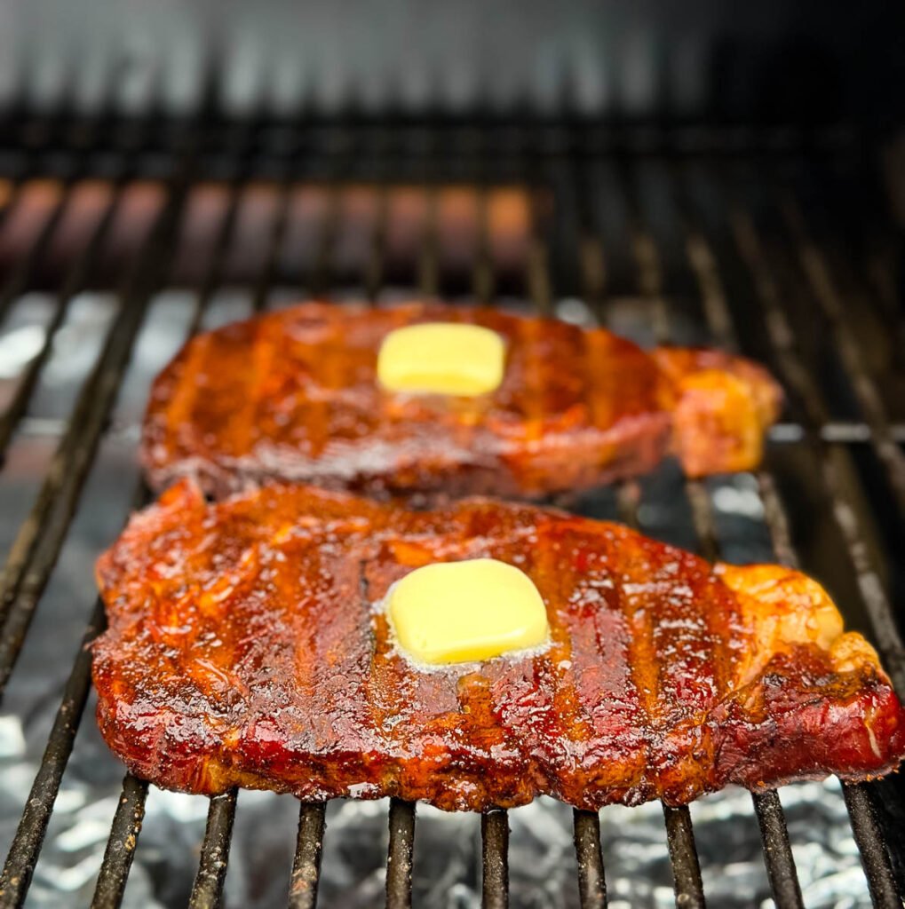 smoked ribeyes with butter on a Traeger smoker grill