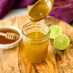 a spoonful of honey lime salad dressing over a glass jar