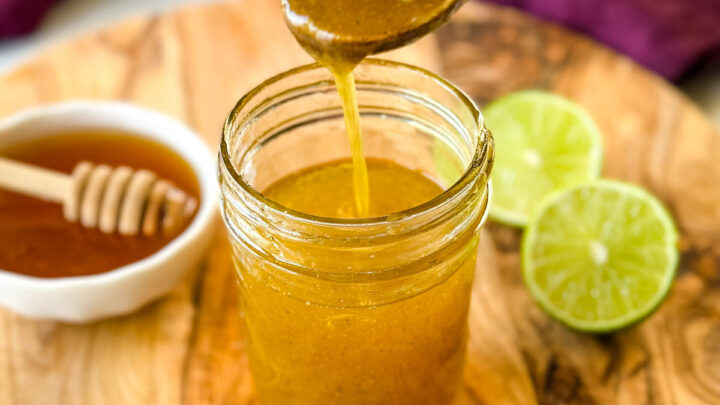 a spoonful of honey lime salad dressing over a glass jar