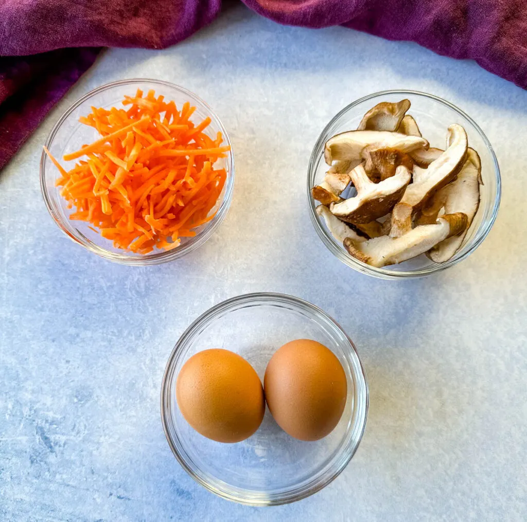 carrots, shiitake mushrooms, and eggs in separate bowls