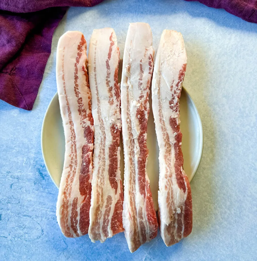 raw pork belly strips on a plate