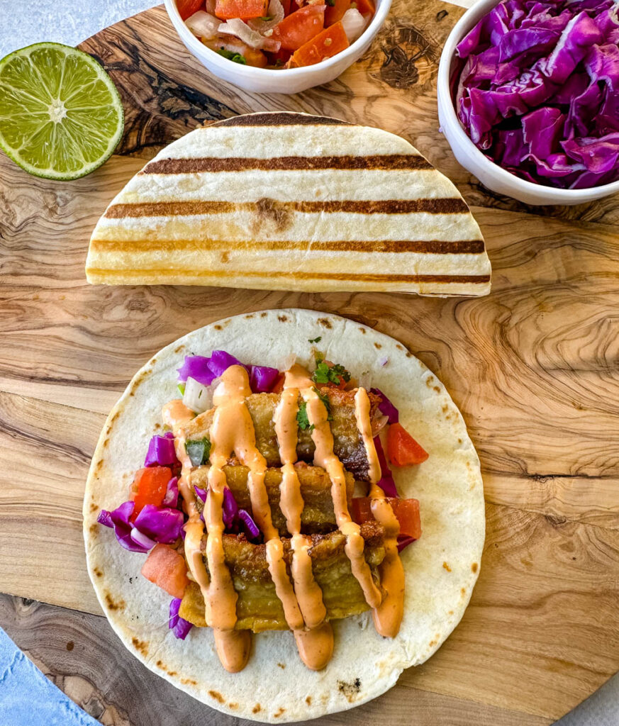 pork belly taco with seared flour tortilla and spicy Chipotle sauce and pico de gallo