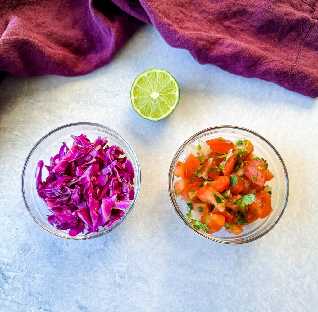 red cabbage, pico de gallo, and fresh limes on a flat surface