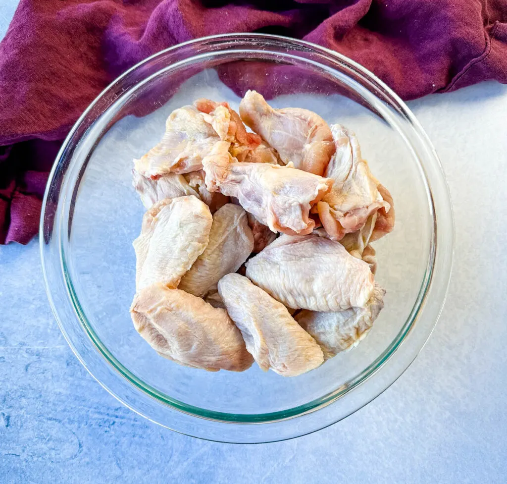 raw chicken wings in a glass bowl