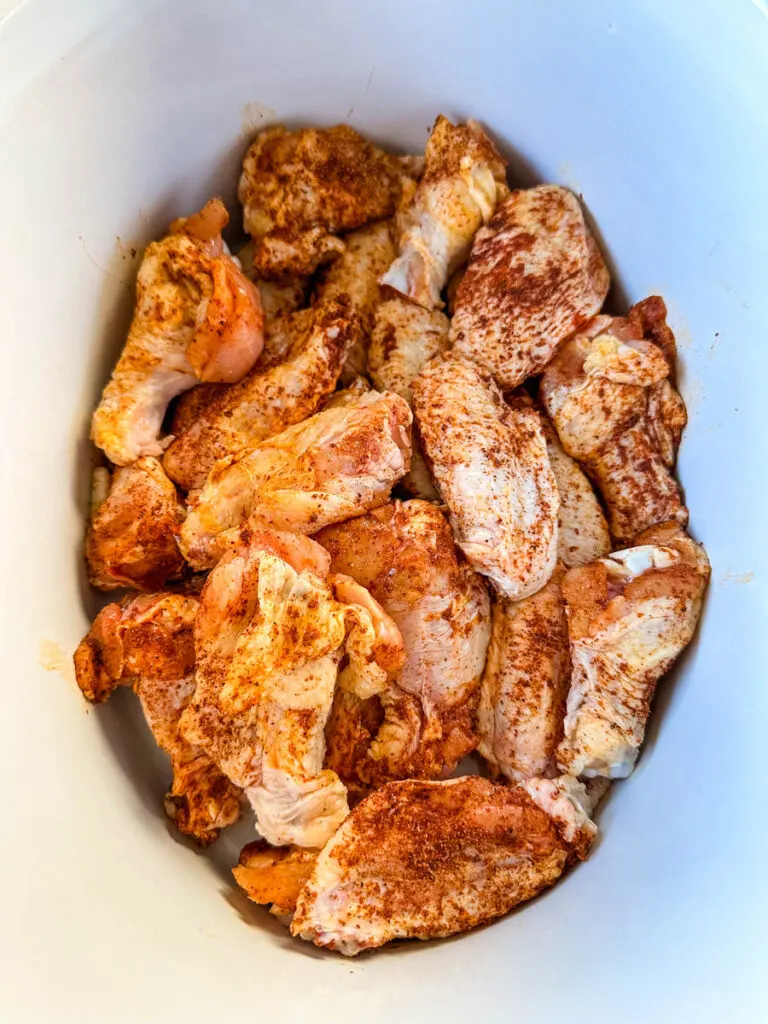raw seasoned chicken wings in a Crockpot slow cooker