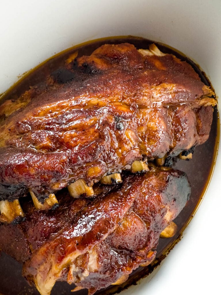 BBQ ribs in a Crockpot slow cooker with BBQ sauce